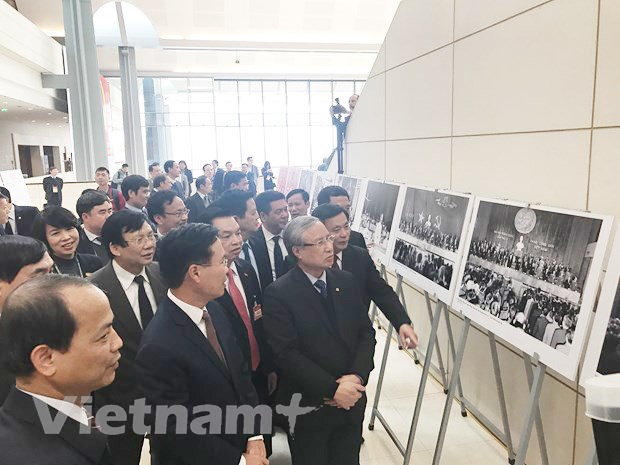 Đồng chí Trần Quốc Vượng và các đại biểu tham quan khu Trưng bày ảnh 'Vững bước dưới cờ Đảng quang vinh' do Thông tấn xã Việt Nam chủ trì