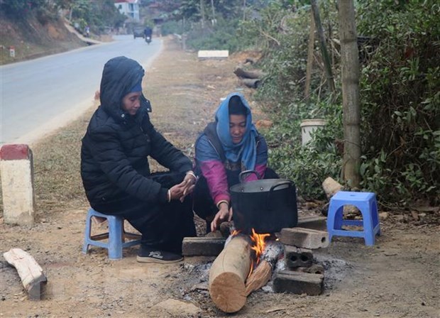 Người dân sinh sống dưới chân đèo Pha Đin, cạnh Quốc lộ 6 đốt lửa sưởi ấm, chống chọi với giá lạnh