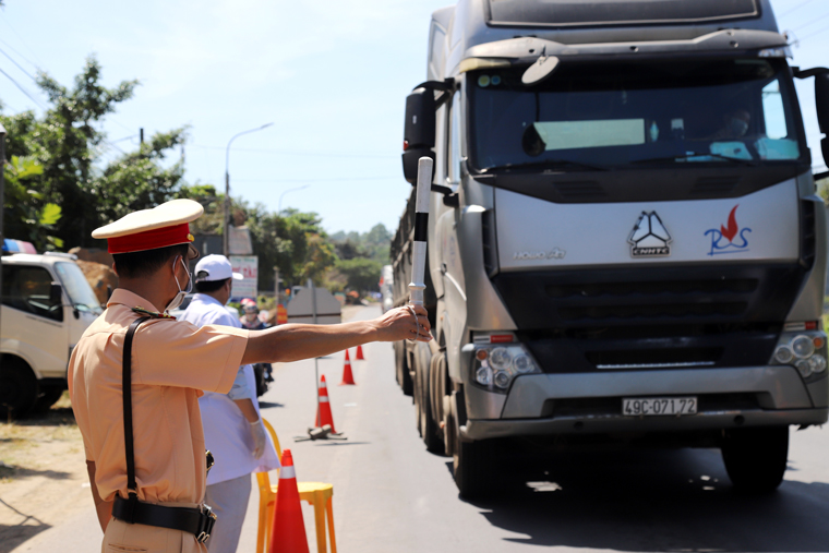 Lực lượng CSGT ra hiệu lệnh dừng xe để kiểm soát, kiểm tra thân nhiệt tài xế và người dân trên các phương tiện