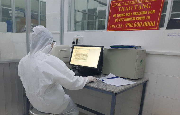 Kỹ thuật viên đang làm việc trên hệ thống máy Realtime RT- PCR xét nghiệm SARS-CoV-2 tại Trung tâm Kiểm soát Bệnh tật tỉnh