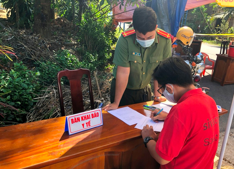 Lực lượng chức năng hướng dẫn người dân khai báo y tế khi qua chốt kiểm soát đặt tại Tỉnh lộ 721 (xã Đoàn Kết, huyện Đạ Huoai)