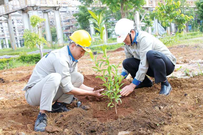 Ông Nguyễn Quang Thuyết - Phó Giám đốc Công ty Nhôm (phải) cùng tham gia trồng cây tại Phân xưởng Trạm Mạng