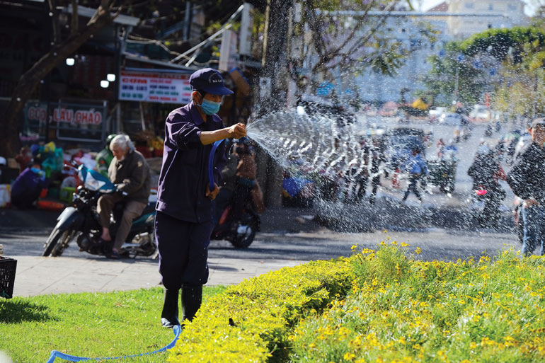 Công nhân tưới hoa mới trồng phục vụ dịp tết tại vòng xuyến Chợ Đà Lạt