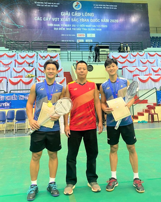 2 tay vợt Nguyễn Đình Hoàng (bên trái), Trần Đình Mạnh (bên phải) cùng HLV Lê Trí Dũng (giữa)