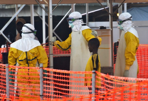 Nhân viên y tế hướng dẫn bệnh nhân nhiễm Ebola tại trung tâm điều trị ở Conakry, Guinea, ngày 21/8/2015.