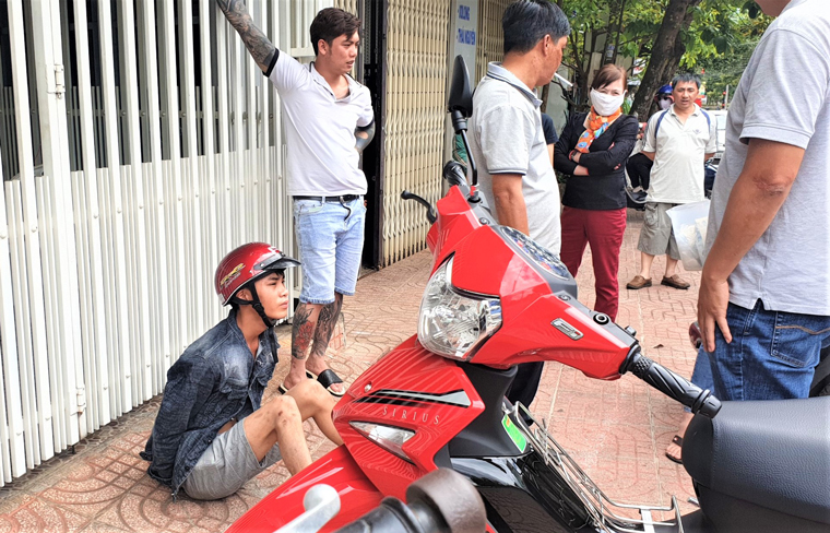 Nguyễn Minh Tưởng (đội nón bảo hiểm) bị Công an và người dân bắt giữ sau khi đối tượng cướp giật vé số của cụ Nguyễn Thị Xuân