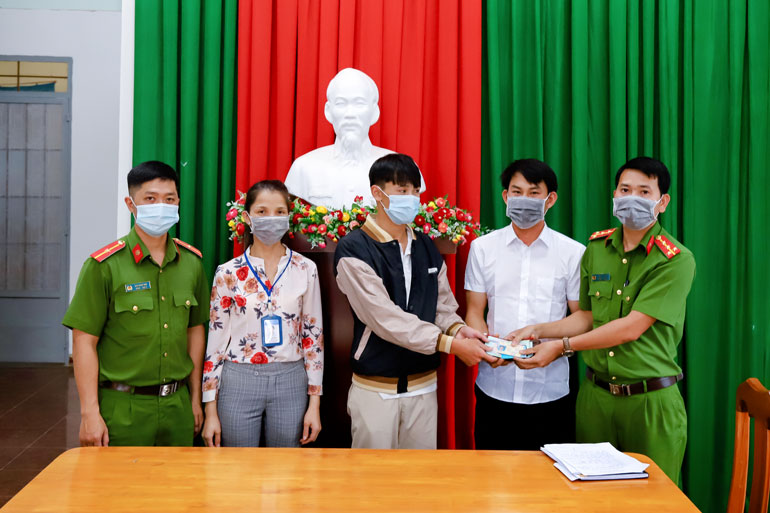 Công an huyện Bảo Lâm cùng em Nguyễn Viết Thuận (thứ 3 từ phải qua) trao trả lại chiếc bóp cho anh Vũ Văn Tiến
