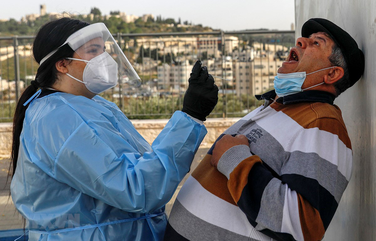 Nhân viên y tế Israel lấy mẫu xét nghiệm COVID-19 cho người dân tại Jerusalem ngày 14/12/2020