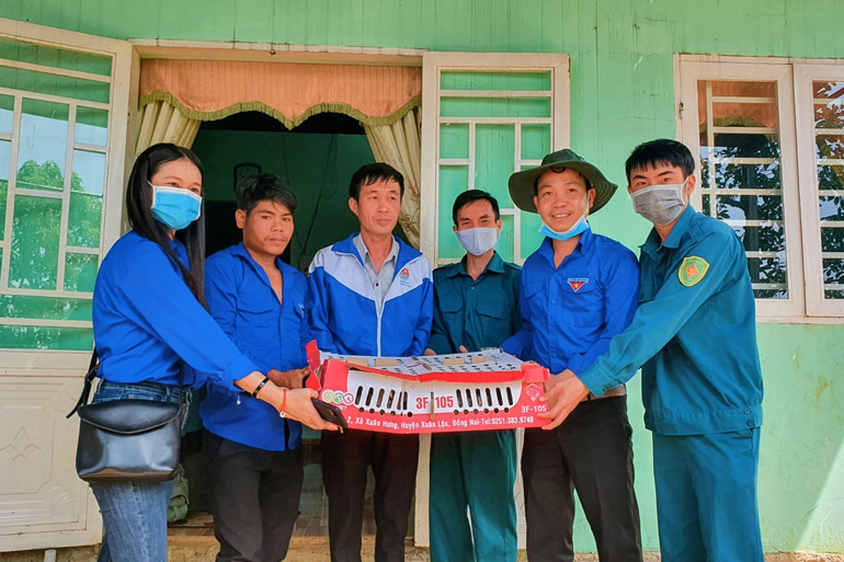 Anh K’Bầu (thứ 2 từ trái qua) nhận gà giống từ Đoàn Thanh niên phường B’Lao trao tặng