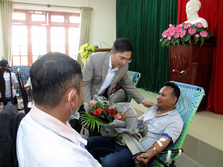 Ông Đặng Trí Dũng - Phó Chủ tịch UBND tỉnh tặng hoa cho anh Liêng Hót Ha Lin đã thứ 9 hiến máu tình nguyện