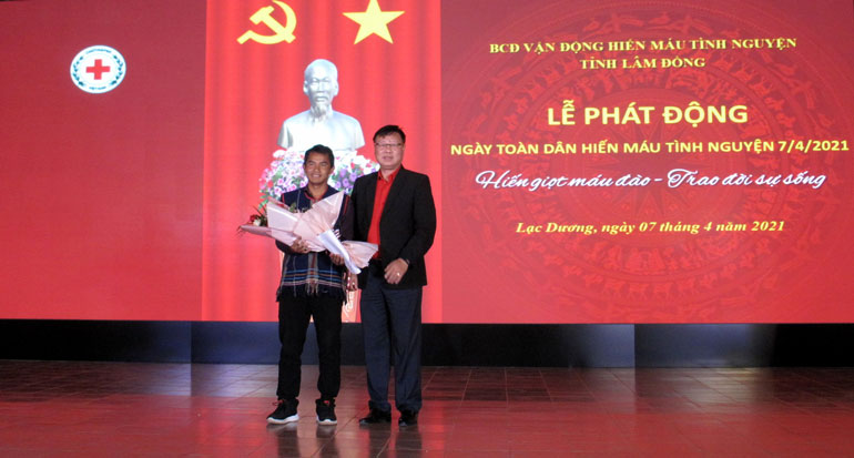 Ông Đỗ Hoàng Tuấn - Chủ tịch Hội CTĐ tỉnh tặng hoa cho anh Cil Mup Ha Sia - ở Tổ dân phố Đăng Gia Dềt B (Thị trấn Lạc Dương) - điển hình hiến máu tình nguyện hưởng ứng lễ phát động