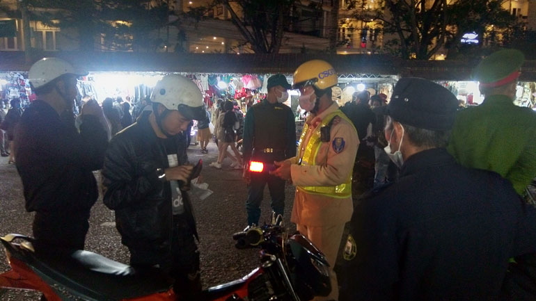 Lực lượng chức năng nhắc nhở 2 trường hợp đi xe moto không đeo khẩu trang tại chợ đêm Đà Lạt