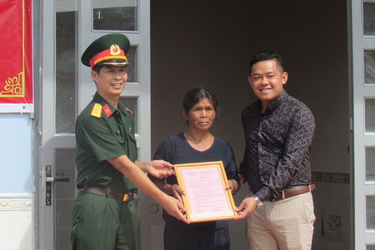Đại diện Ban Chỉ huy Quân sự huyện Bảo Lâm và đại diện nhà tài trợ trao quyết định bàn giao nhà cho bà Ka Mợs