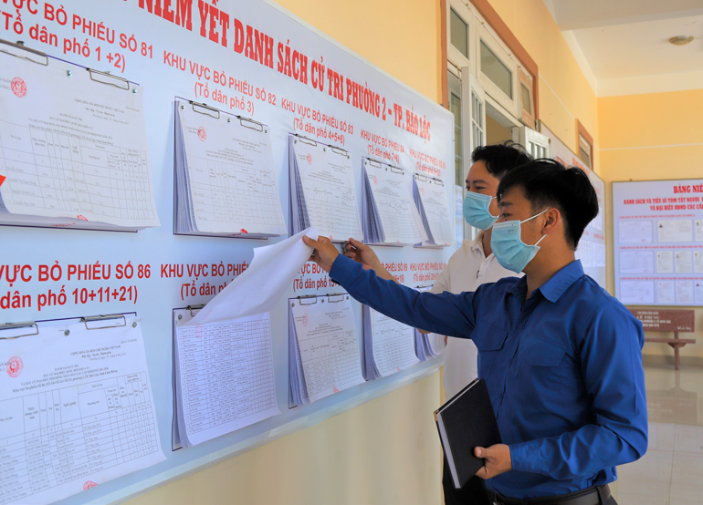 Người dân Tp Bảo Lộc tìm hiểu về các ứng cử viên đại biểu Quốc hội khóa XV và HĐND các cấp nhiệm kỳ 2021 - 2026 tại các điểm niêm yết. Ảnh: Khánh Phúc