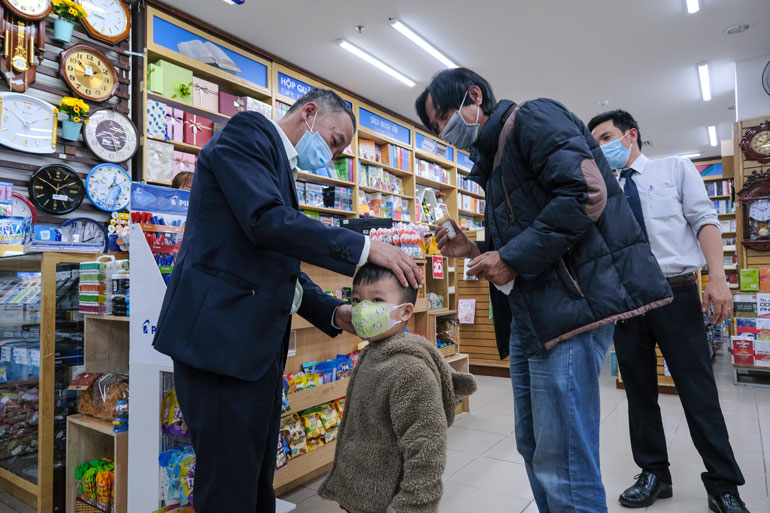 Chủ tịch UBND tỉnh Trần Văn Hiệp đeo khẩu trang cho 1 cháu nhỏ tại siêu thị và nhắc nhở người thân trong gia đình cháu trai chú tâm phòng, dịch, phải đeo khẩu trang mọi lúc, mọi nơi ở môi trường công cộng, đông người qua lại