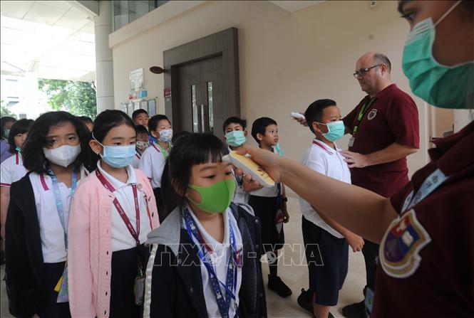 Kiểm tra thân nhiệt phòng lây nhiễm COVID-19 tại một trường học ở Tangerang, Indonesia