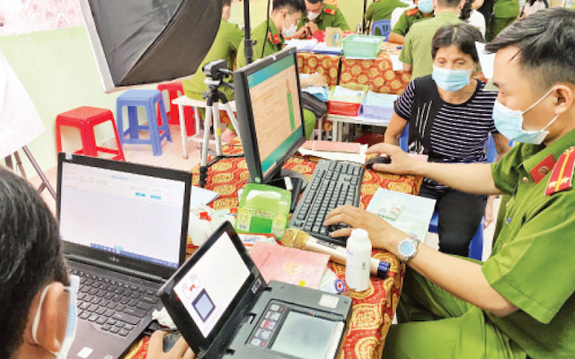Cán bộ công an hỗ trợ người dân làm thẻ căn cước công dân có gắn chíp tại Nhà văn hóa liên phường Bình Trị Đông, quận Bình Tân