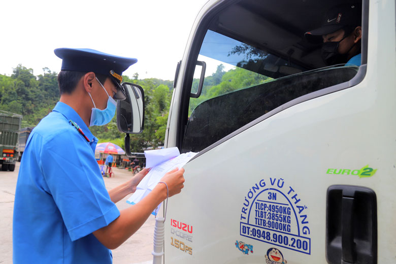 Kiểm tra phiếu xét nghiệm Covid-19 của tài xế và phụ xe tải vận chuyển hàng hóa tại Chốt số 1 (Quốc lộ 20, Đạ Huoai). Ảnh: Khánh Phúc