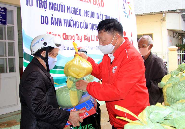 Ông Đỗ Hoàng Tuấn - Chủ tịch Hội Chữ thập đỏ tỉnh giúp đỡ các cụ mua hàng tại Chợ Nhân đạo