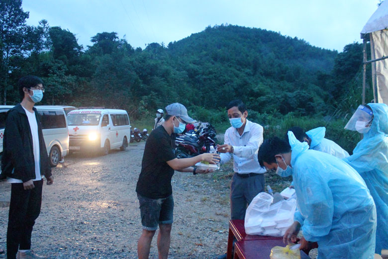 Đồng chí Lưu Hồng Long - Phó Chủ tịch UBND huyện Đạ Huoai cùng lực lượng làm nhiệm vụ phát cơm, nước uống miễn phí đến người chờ đi cách ly