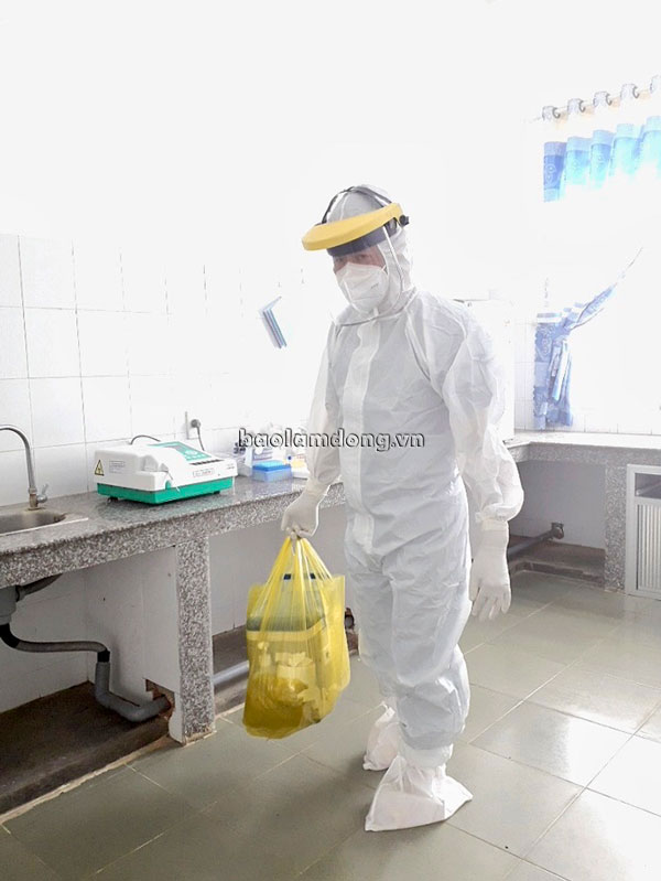 Kỹ thuật viên chuẩn bị bước vào phòng bệnh nhân để lấy mẫu xét nghiệm SARS-CoV-2 tại Khu cách ly điều trị Covid-19 Ka Đô –huyện Đơn Dương.