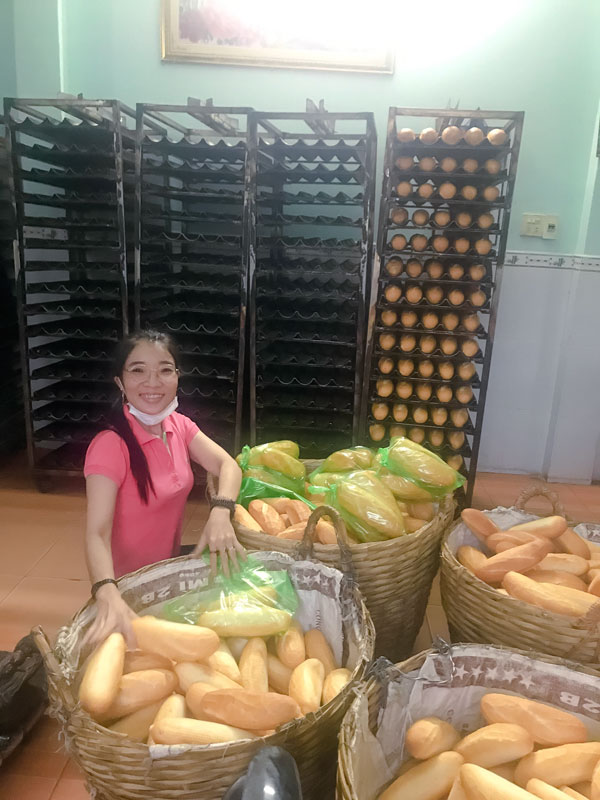 Chị Hòa đang đóng bánh mì trước khi chở đi trao cho người dân trên địa bàn.