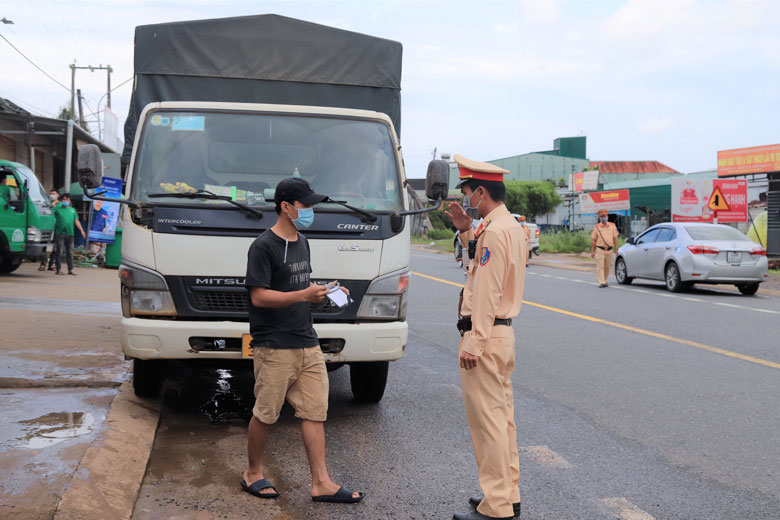 Lực lượng cảnh sát giao thông kiểm tra, xử lý các tài xế xe tải dừng đỗ giao nhận hàng hóa trên Quốc lộ 20 đoạn qua xã Lộc An (huyện Bảo Lâm) vi phạm quy đinh phòng chống dịch