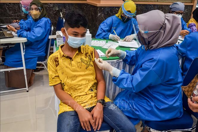 Nhân viên y tế tiêm vaccine ngừa COVID-19 cho một thiếu niên tại Pekanbaru, Riau, Indonesia, ngày 9/7/2021