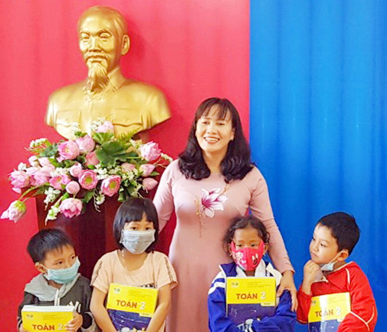 Giám đốc Sở GDĐT Phạm Thị Hồng Hải và học sinh lớp 2 huyện Di Linh đón nhận sách giáo khoa mới năm học 2021-2022