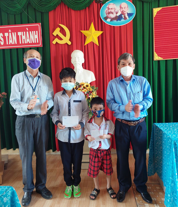 Đồng chí Nguyễn Văn Cường - Chủ tịch UBND huyện, trao quà cho các em học sinh vượt khó, học giỏi