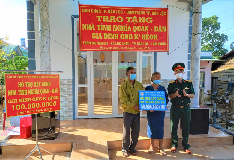 Trung tá Trần Hữu Linh – Chính trị viện Ban Chỉ huy Quân sự TP Bảo Lọc trao bảng biểu trương hỗ trợ kinh phí xây dựng nhà cho gia đình ông K’Hẻoh