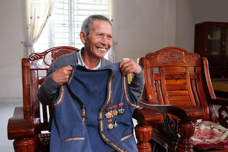 Ông Tou Prong Dzung khoe chiếc áo gắn nhiều huy hiệu - kỷ niệm chương mà ông cất giữ lâu nay