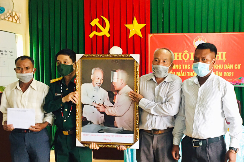 Đại tá Nguyễn Bình Sơn -  Ủy viên Ban Thường vụ Tỉnh ủy, Chỉ huy trưởng Bộ CHQS tỉnh trao quà và bức ảnh Bác Hồ - Bác Tôn, biểu tượng của tình đoàn kết cho Nhân dân thôn Đa Tế, xã Đạ M'Rông