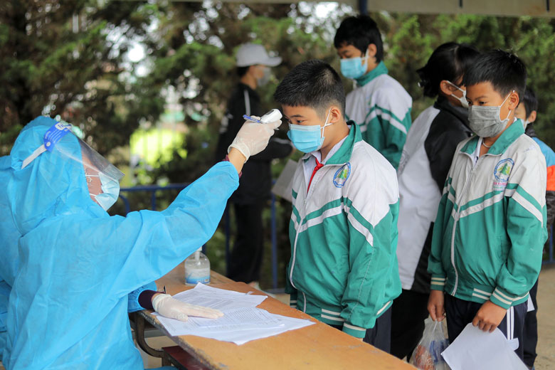 Tại cổng trường, các em được cán bộ y tế Trung tâm Y tế huyện Đức Trọng đo thân nhiệt, rửa tay sát khuẩn