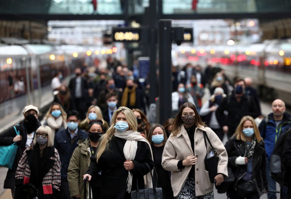 Người dân đeo khẩu trang khi di chuyển tại nhà ga ở London (Anh)