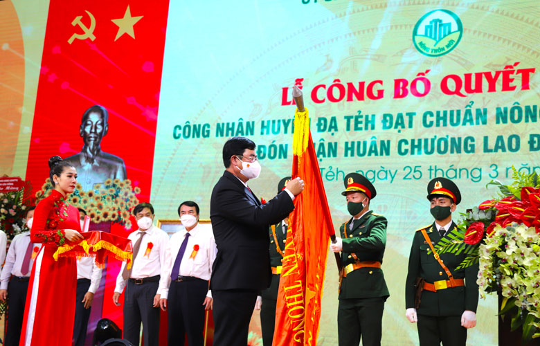 Thừa ủy quyền của Chủ tịch nước, đồng chí Trần Đình Văn - Phó Bí thư Thường trực Tỉnh ủy Lâm Đồng thực hiện nghi thức gắn Huân lao động Hạng III lên Quốc kỳ cho huyện Đạ Tẻh.