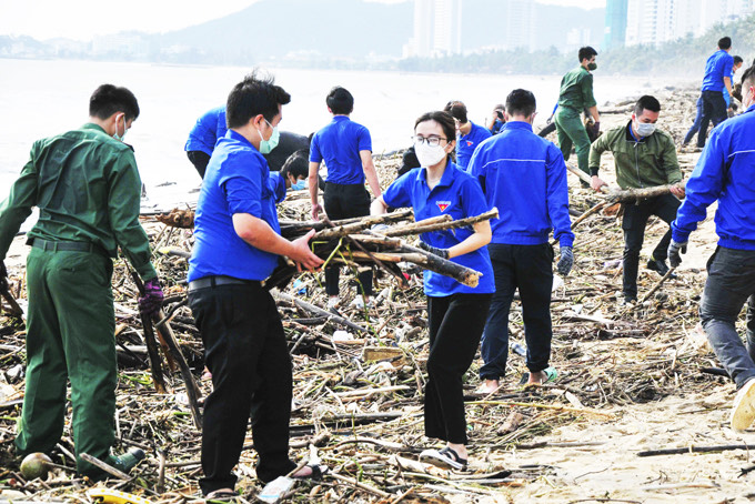 Đoàn viên thanh niên tham gia dọn dẹp vệ sinh môi trường biển sau đợt mưa lớn kéo dài. 