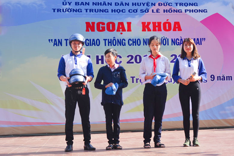Học sinh Trường THCS Lê Hồng Phong được hướng dẫn đội mũ bảo hiểm tại một buổi sinh hoạt ngoại khóa về an toàn giao thông do trường tổ chức