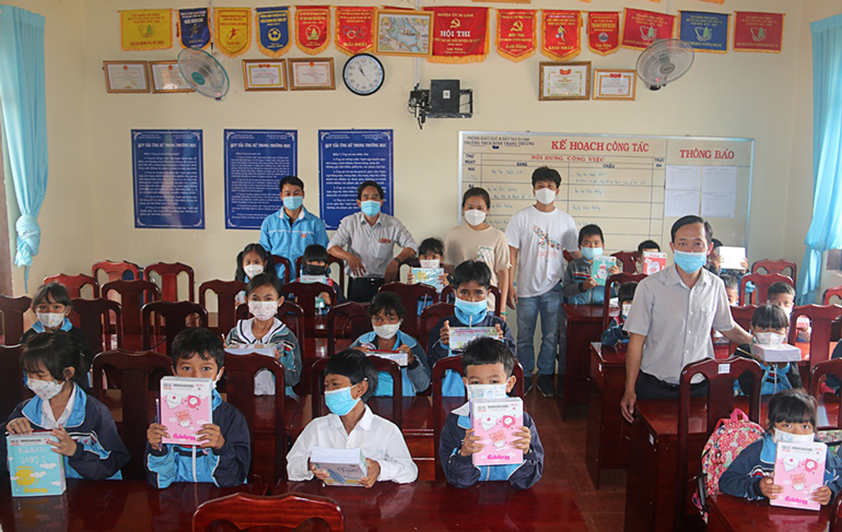 Chị Nguyễn Lữ Thị Thùy Mỵ cùng Ban Giám hiệu nhà trường trao quà cho học sinh