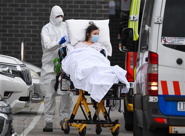 Nhân viên y tế chuyển bệnh nhân COVID-19 lên xe cứu thương tại thành phố Melbourne, Australia