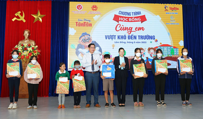 Ông Huỳnh Thanh Mừng và bà Trần Thị Chúc Quỳnh trao học bổng cho các học sinh   