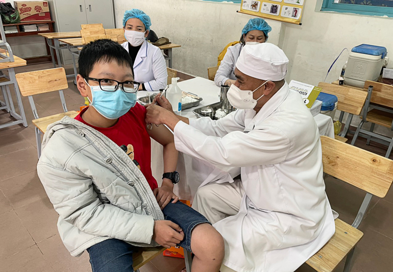 Thượng tọa Thích Linh Toàn đang tiêm vắc xin phòng COVID-19 cho trẻ em tại Trường Tiểu học Lê Quý Đôn - TP Đà Lạt