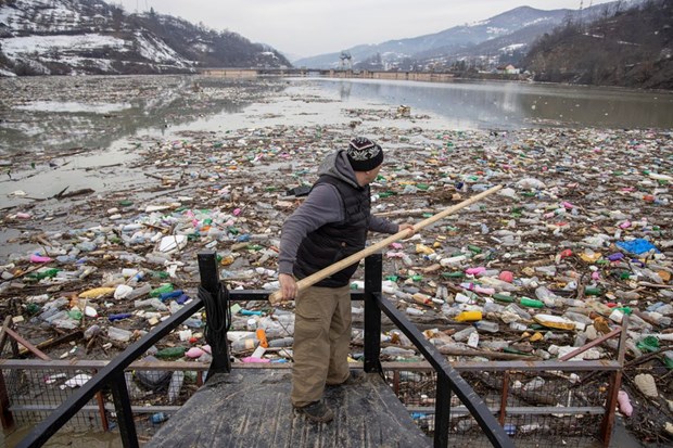 Công nhân thu gom rác thải nhựa tại con đập của nhà máy thủy điện ở Priboj, Serbia