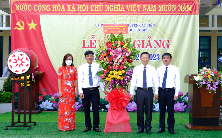 Đồng chí Đặng Trí Dũng cùng lãnh đạo huyện Cát Tiên tặng hoa chúc mừng nhà trường