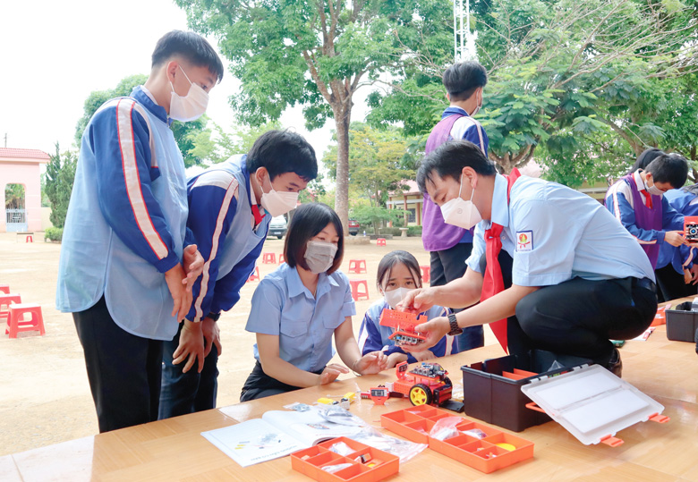 Anh Trần Duy Khôi - Phó Giám đốc Trung tâm Hoạt động Thanh, thiếu nhi tỉnh hướng dẫn học sinh Trường THCS Hoài Đức thực hiện trò chơi Đường đua STEM