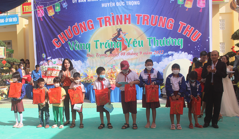 Bà Phạm Thị Thanh Thúy - Phó Chủ tịch UBND huyện và ông Võ Khắc Chương – Phó Trưởng phòng Lao động Thương  binh và Xã hội, trao quà cho các em học sinh có hoàn cảnh khó khăn
