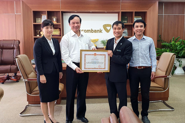 Ông Trần Văn Sơn - Phó Giám đốc BHXH tỉnh trao tặng bằng khen của Tổng Giám đốc BHXH Việt Nam cho ông Nguyễn Văn Chiểu - Giám đốc Vietcombank Lâm Đồng