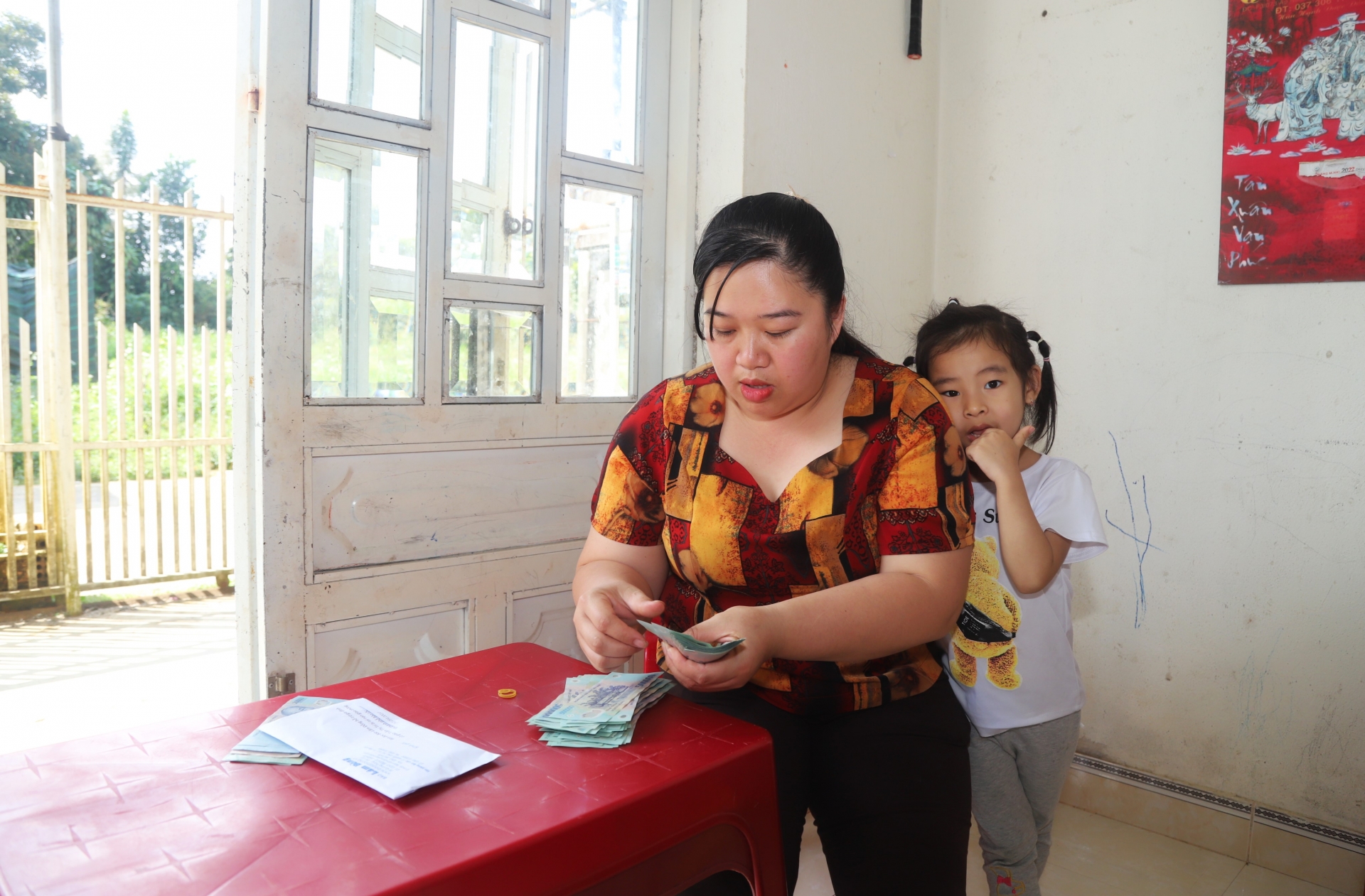 Đại diện trường Mầm non Đạ Nghịch (xã Lộc Châu) nơi cô Trí đang công tác kiểm đếm số tiền bạn đọc hỗ trợ cho gia đình thông qua Báo Lâm Đồng