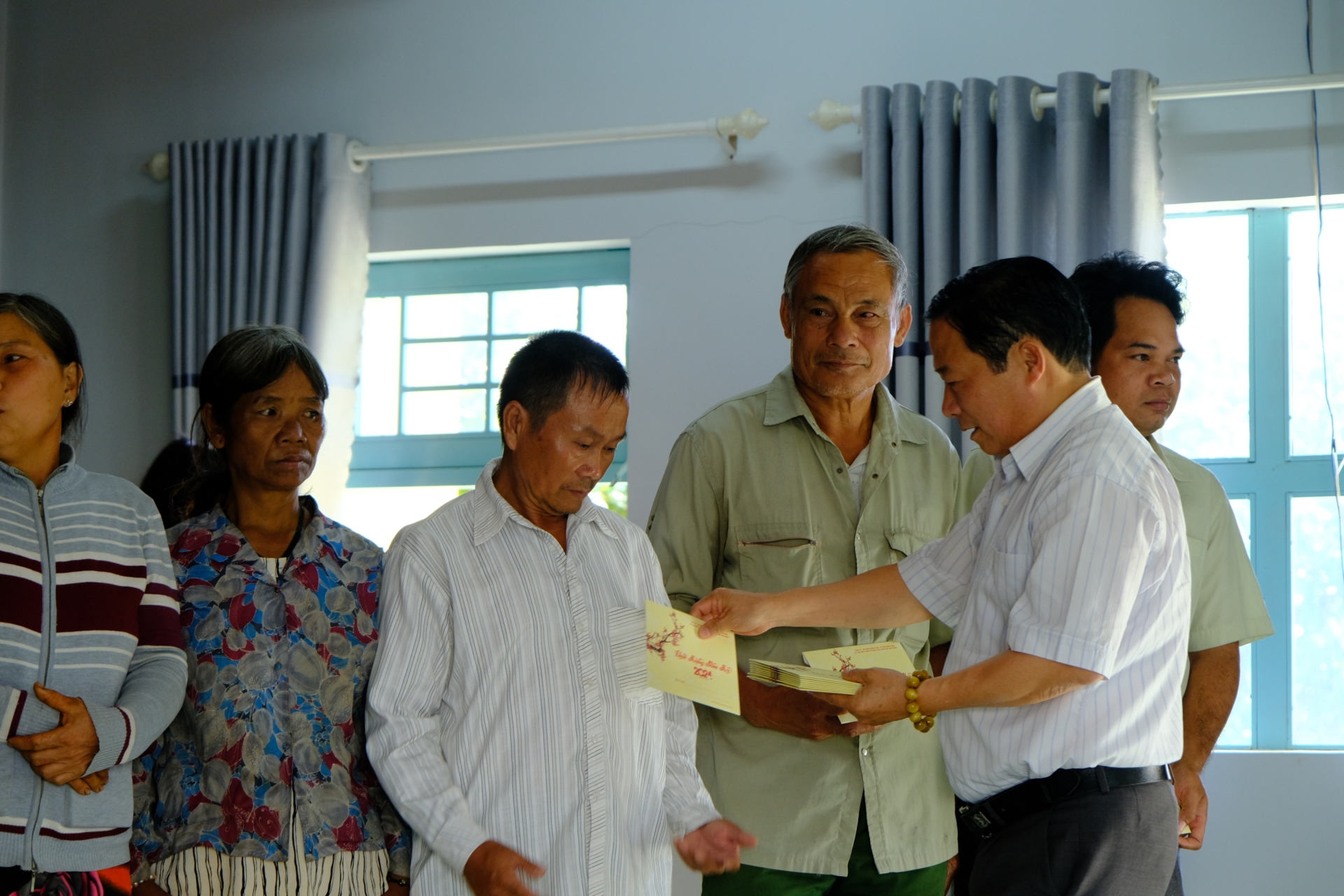 Đồng chí Nguyễn Hữu Ân – Phó Giám đốc Sở Lao động Thương binh và Xã hội tỉnh Lâm Đồng trao tặng các phần quà cho các hộ gia đình. 