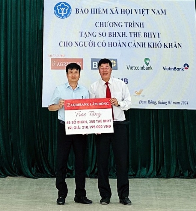 Đại diện Agribank Lâm Đồng trao bảng tượng trưng tài trợ chương trình tặng sổ BHXH, thẻ BHYT cho người dân có hoàn cảnh khó khăn